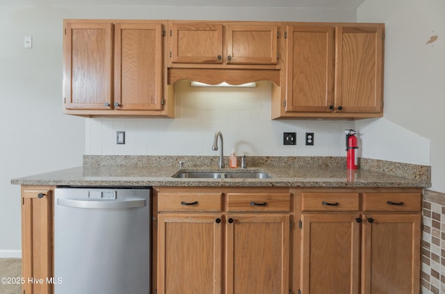 kitchen featuring light stone countertops, tasteful backsplash, stainless steel dishwasher, and sink