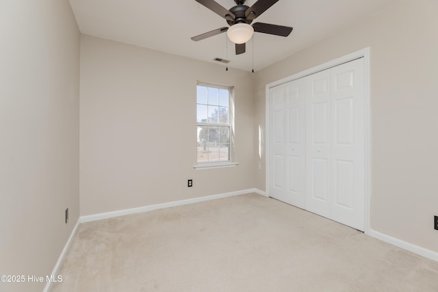 unfurnished bedroom with light carpet, a closet, and ceiling fan