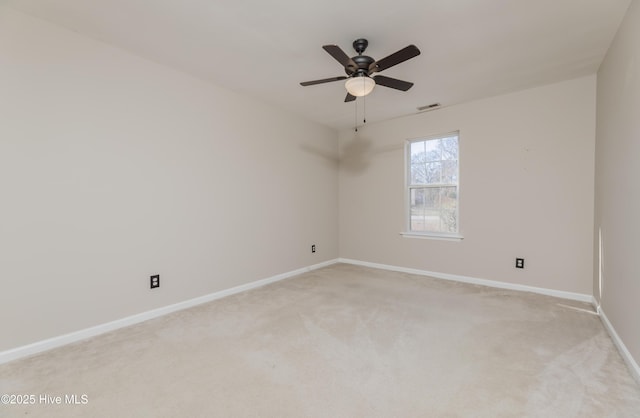 empty room featuring ceiling fan and light carpet