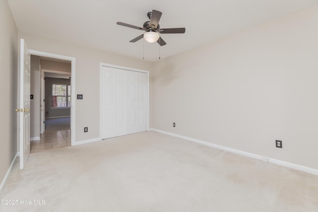 unfurnished bedroom with ceiling fan, light colored carpet, and a closet