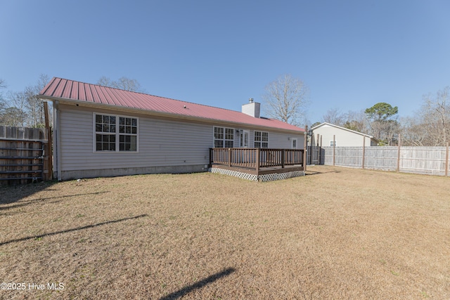 rear view of property with a lawn and a wooden deck