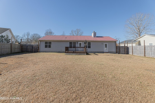 rear view of house featuring a deck and a yard