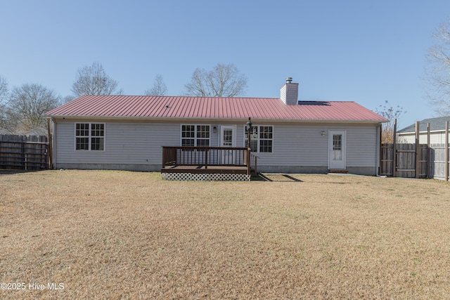 rear view of house with a lawn and a deck