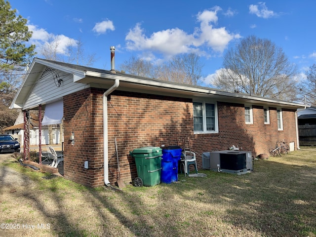 view of home's exterior with a lawn and central AC unit