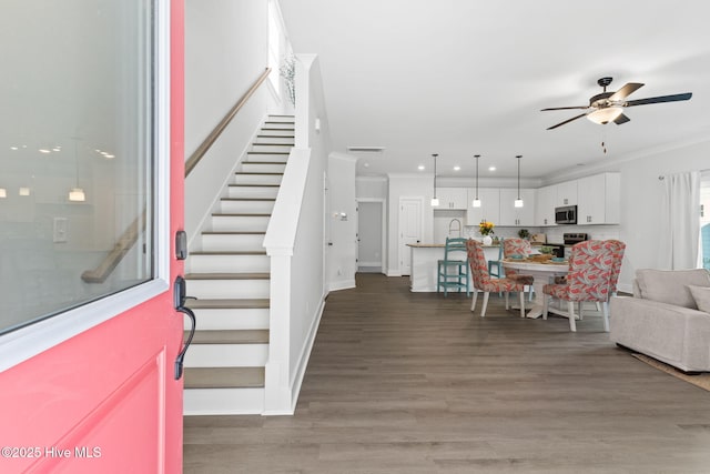 living room featuring crown molding, sink, hardwood / wood-style floors, and ceiling fan