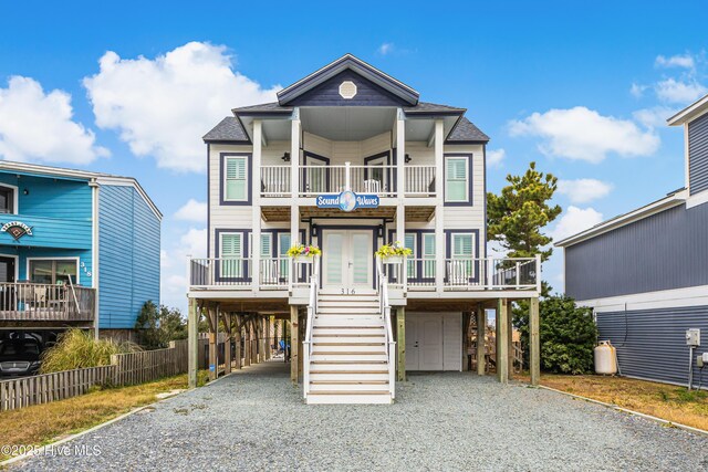 coastal home with a balcony, french doors, and a carport