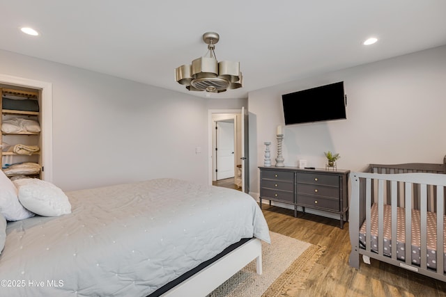 bedroom featuring a notable chandelier, wood finished floors, and recessed lighting