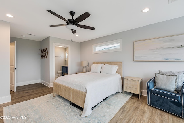 bedroom featuring ceiling fan, wood-type flooring, and ensuite bath