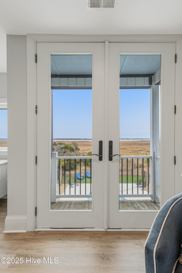 doorway featuring french doors, visible vents, and wood finished floors