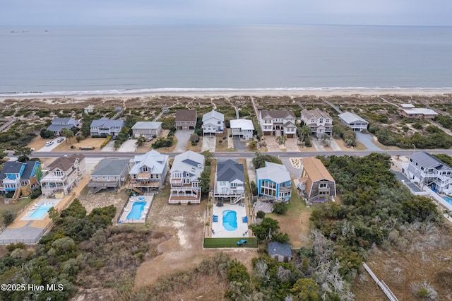 drone / aerial view featuring a water view and a view of the beach