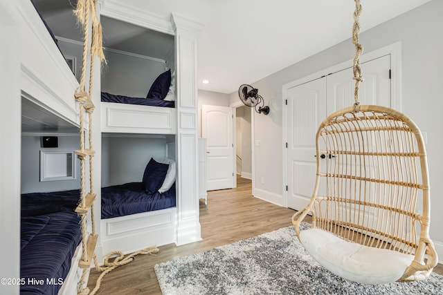 bedroom with light wood finished floors, a closet, recessed lighting, and baseboards