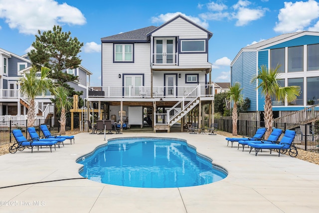 back of property with a balcony, a patio area, fence, and french doors