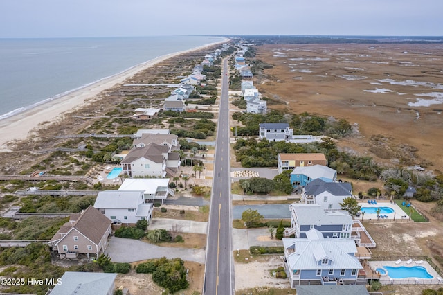 drone / aerial view featuring a water view and a beach view