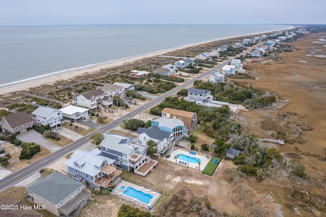 drone / aerial view featuring a water view and a beach view