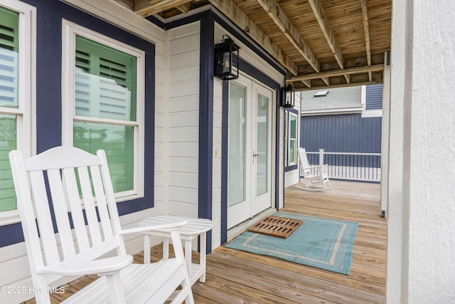 wooden terrace featuring french doors and a porch