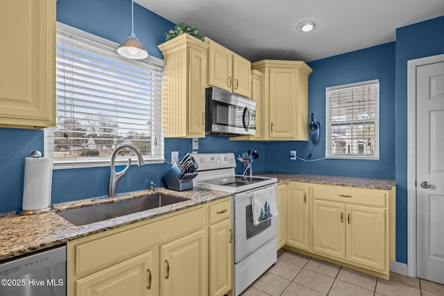 kitchen featuring sink, decorative light fixtures, light tile patterned flooring, light stone counters, and stainless steel appliances