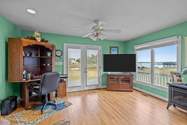 office space featuring french doors, light hardwood / wood-style floors, and ceiling fan