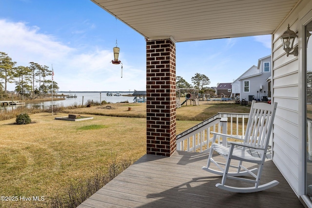 wooden terrace with a lawn and a water view