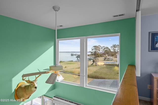 interior space featuring ceiling fan and a water view