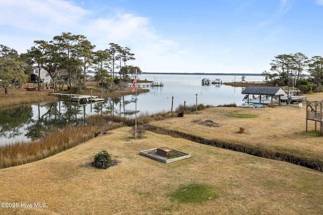 view of dock with a yard and a water view