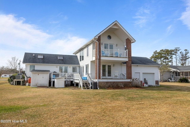 back of property with a yard, a balcony, central AC unit, and a wooden deck