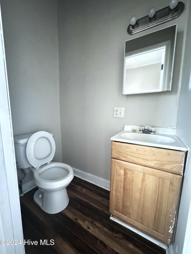 bathroom with vanity, wood-type flooring, and toilet