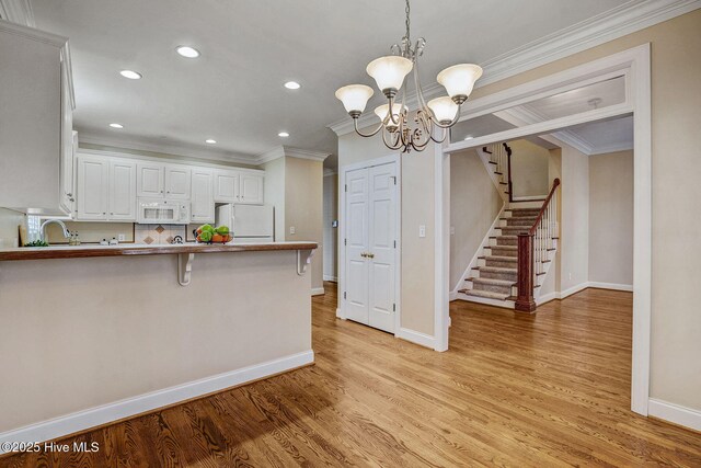 unfurnished room featuring crown molding, wood-type flooring, and a notable chandelier