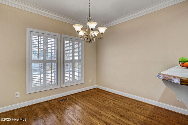 unfurnished room featuring a notable chandelier, plenty of natural light, wood-type flooring, and crown molding