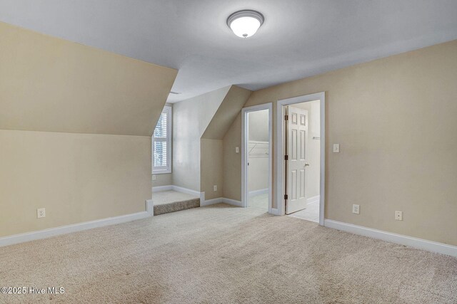 spacious closet with light carpet and vaulted ceiling