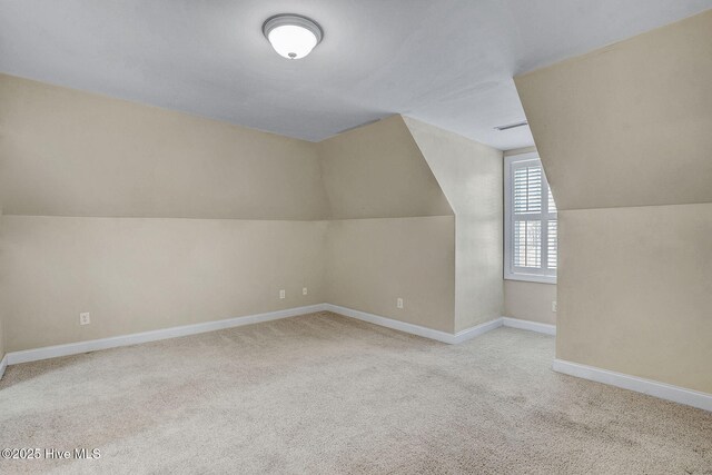 walk in closet with light carpet and lofted ceiling