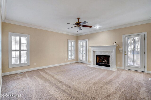 spare room with ceiling fan, crown molding, light carpet, and a wealth of natural light