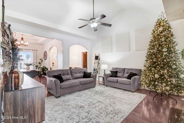 living room featuring a tray ceiling, light hardwood / wood-style flooring, and ceiling fan with notable chandelier