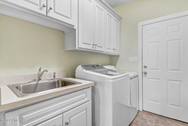 laundry area with cabinets, independent washer and dryer, and sink