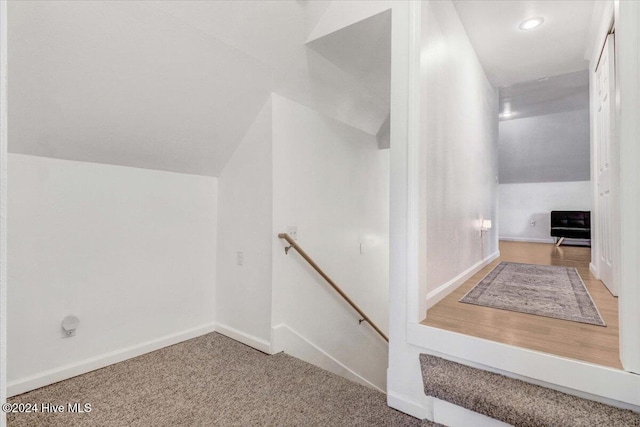 stairway with carpet and lofted ceiling