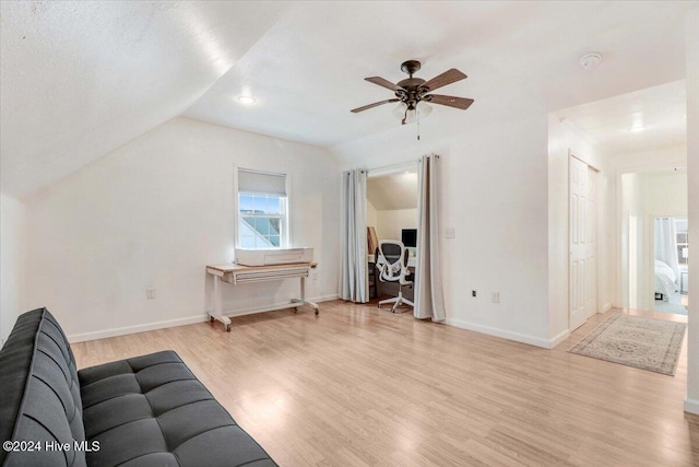 living room featuring ceiling fan, light hardwood / wood-style floors, a textured ceiling, and vaulted ceiling