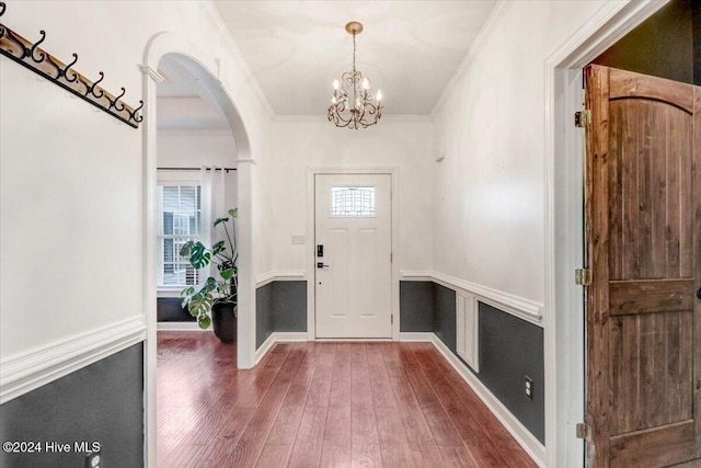 foyer featuring ornamental molding, dark wood-type flooring, and a notable chandelier