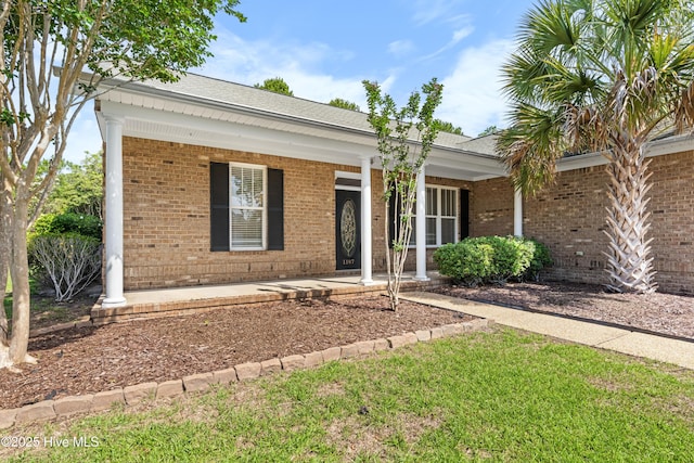 1107 Veranda Ct, Leland, NC 28451 - ranch-style home with brick siding, a porch, and a shingled roof