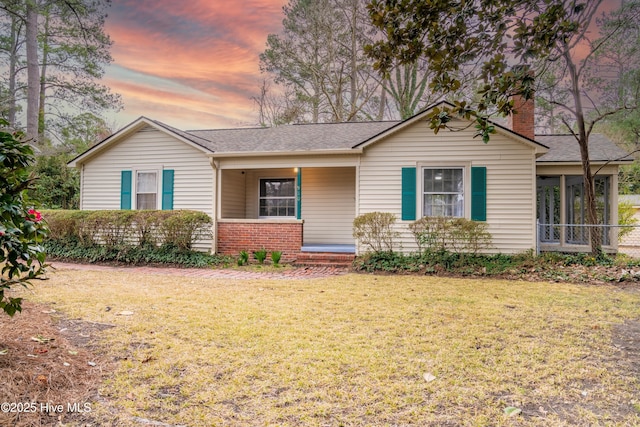 ranch-style home with a sunroom and a yard