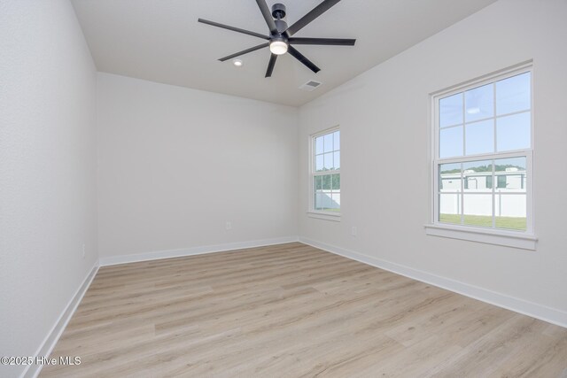 empty room with ceiling fan and light hardwood / wood-style floors