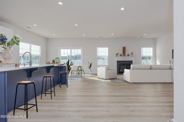 kitchen featuring a kitchen bar, sink, and light hardwood / wood-style flooring