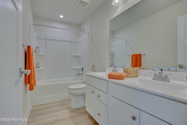 full bathroom featuring hardwood / wood-style flooring, vanity, toilet, and shower / tub combination