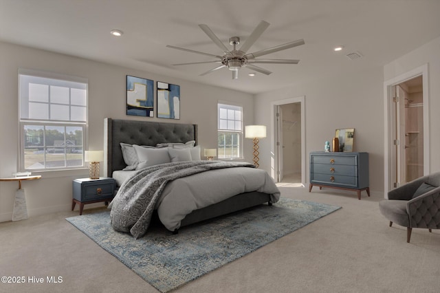 carpeted bedroom featuring ceiling fan, a walk in closet, and a closet