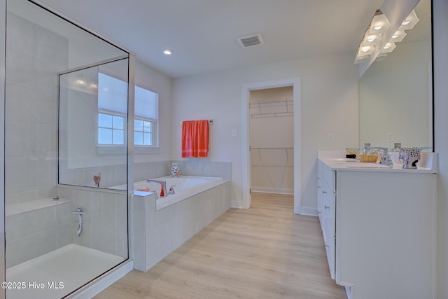 bathroom with shower with separate bathtub, vanity, and hardwood / wood-style flooring