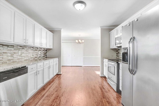 kitchen featuring appliances with stainless steel finishes, tasteful backsplash, white cabinetry, and light stone counters