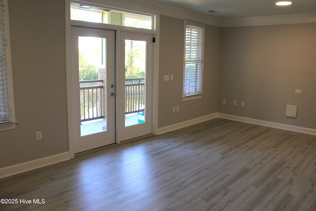 entryway with a healthy amount of sunlight, dark hardwood / wood-style flooring, ornamental molding, and french doors