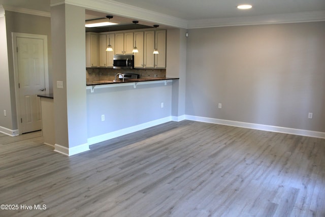 kitchen with backsplash, kitchen peninsula, crown molding, and light hardwood / wood-style floors