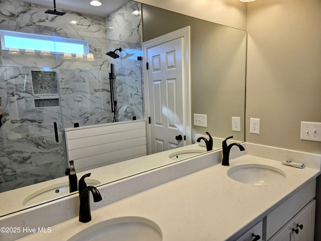 bathroom featuring a shower with door and vanity