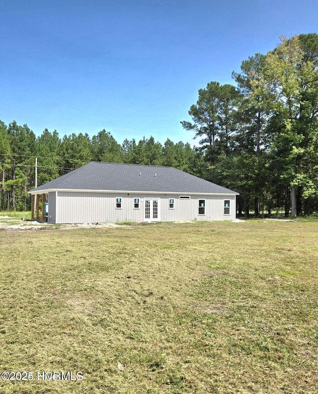 rear view of property with french doors and a lawn