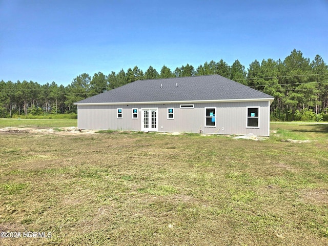 back of property with a lawn and french doors