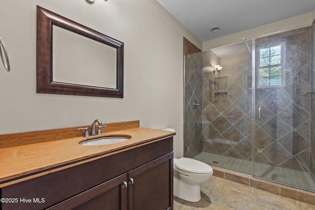 bathroom featuring tile patterned floors, vanity, toilet, and walk in shower